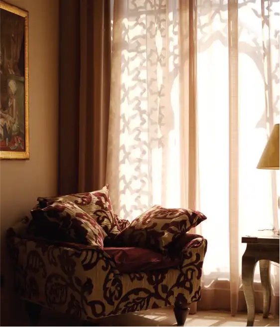 A corner of the room featuring a patterned armchair with plush cushions at Miramar Al Aqah Resort