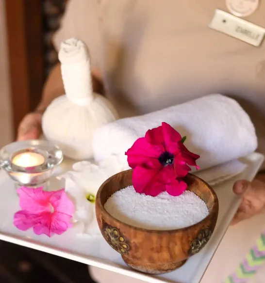 Spa products and white towel with orchids at Avitane spa in Miramar Al Aqah Resort