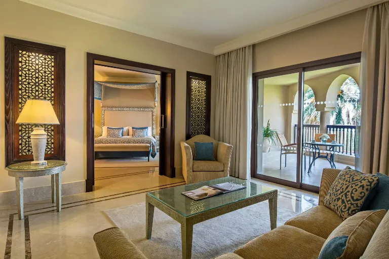 Bedroom and living area with a private balcony at Al Rawda Suite in Miramar Al Aqah Resort