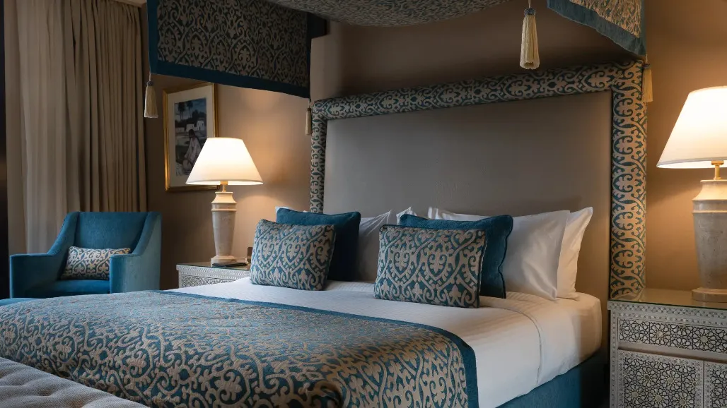 A queen size bed and table lamps at the Al Bawadi Suite in Miramar Al Aqah Beach Resort