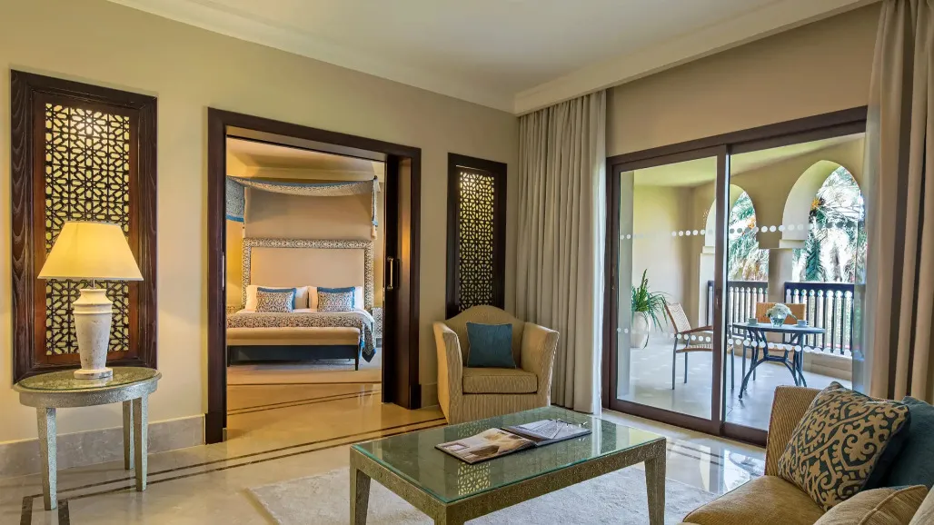 Bedroom and living area with a private balcony at Al Rawda Suite in Miramar Al Aqah Resort